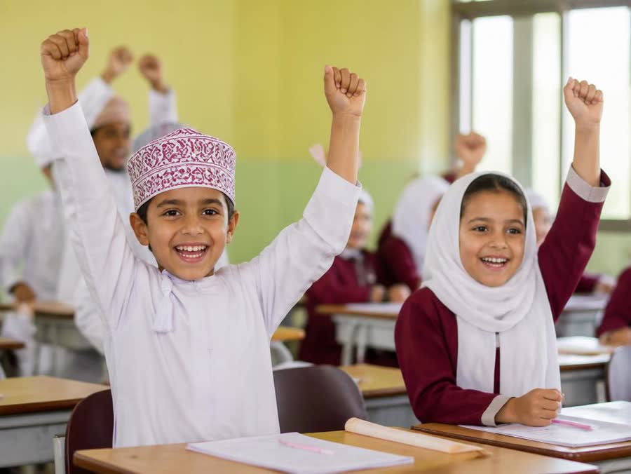 Omani students cheering with raised hands after finishing an activity
